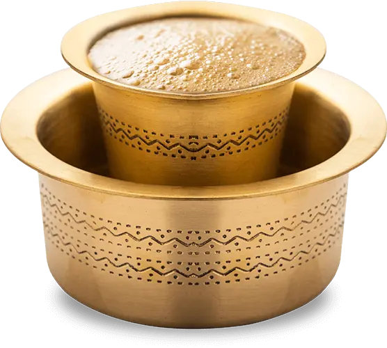 Image of South Indian filter coffee served in a traditional brass davara set, featuring a frothy top and rich, aromatic brew